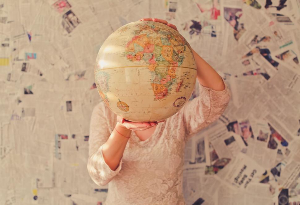 Free Image of Woman Holding Globe in Front of Face 