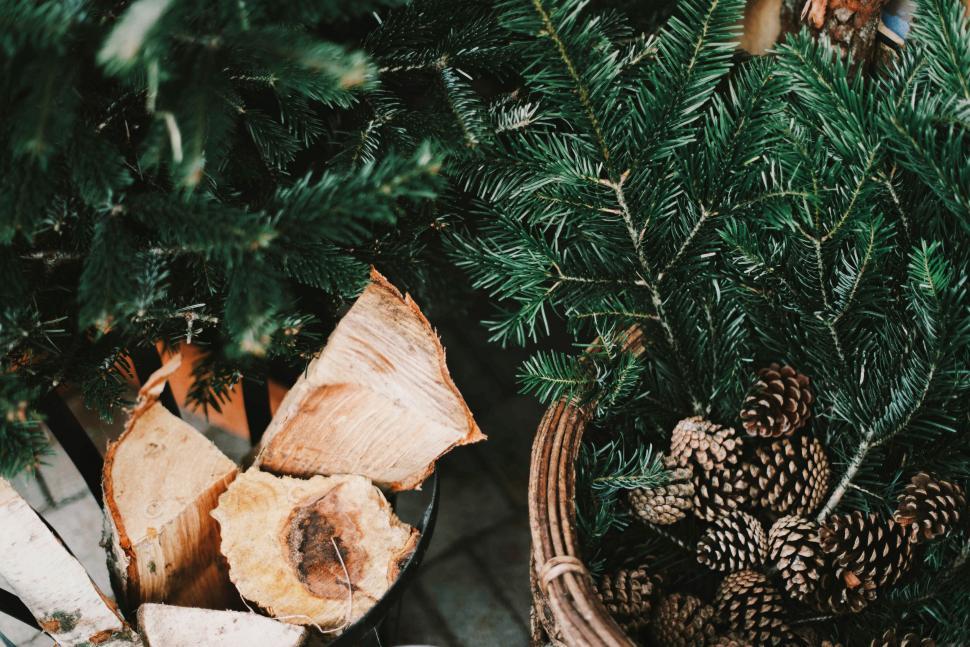 Free Image of Basket Filled With Pine Cones Next to Pile of Logs 