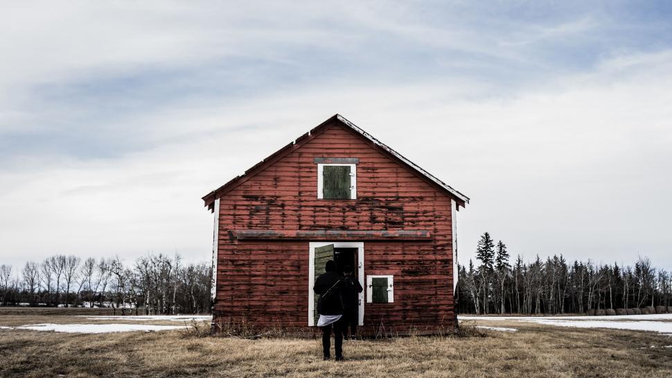 Free Image of Person Standing in Front of Red Barn 