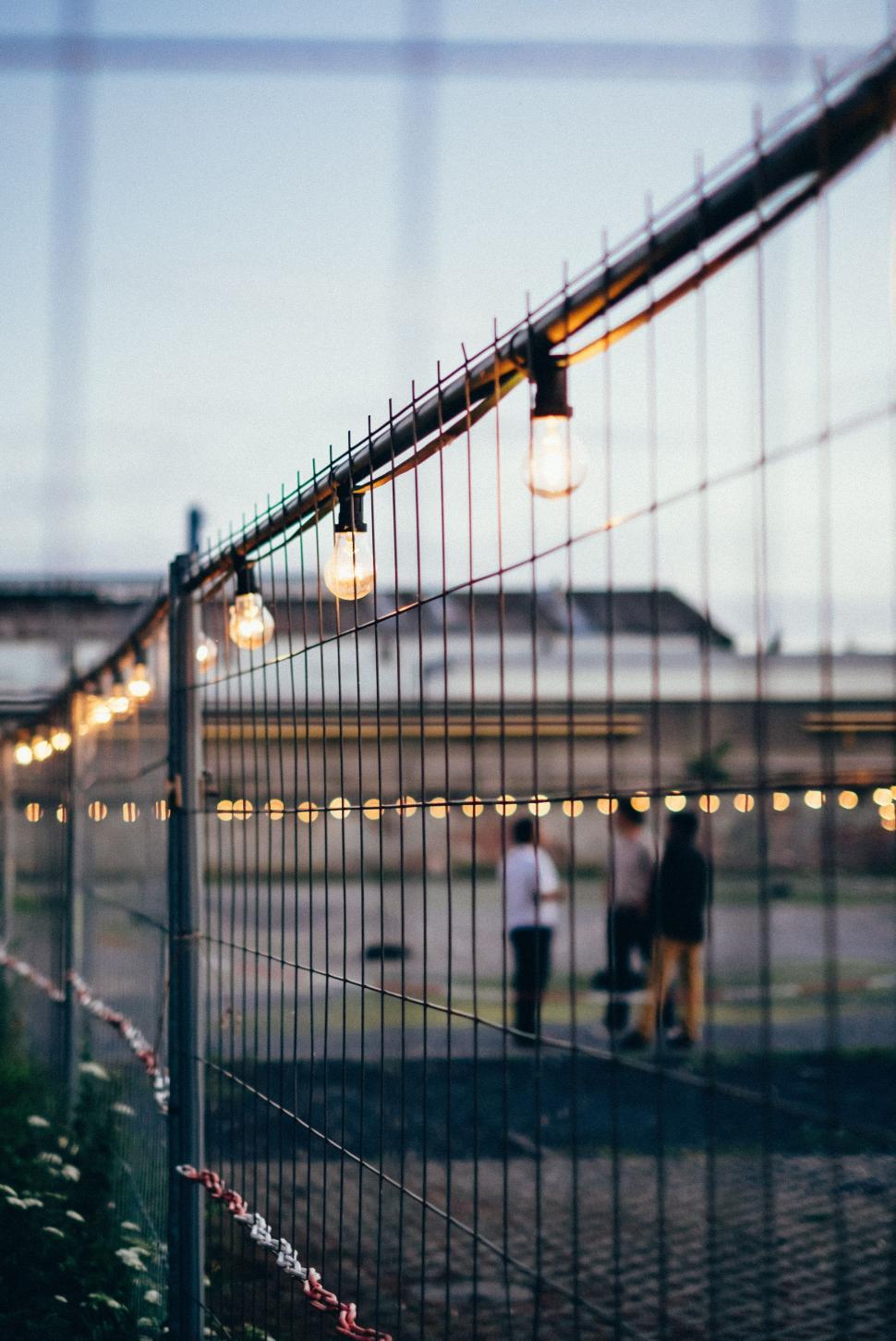 Free Image of Couple Standing Next to Fence 
