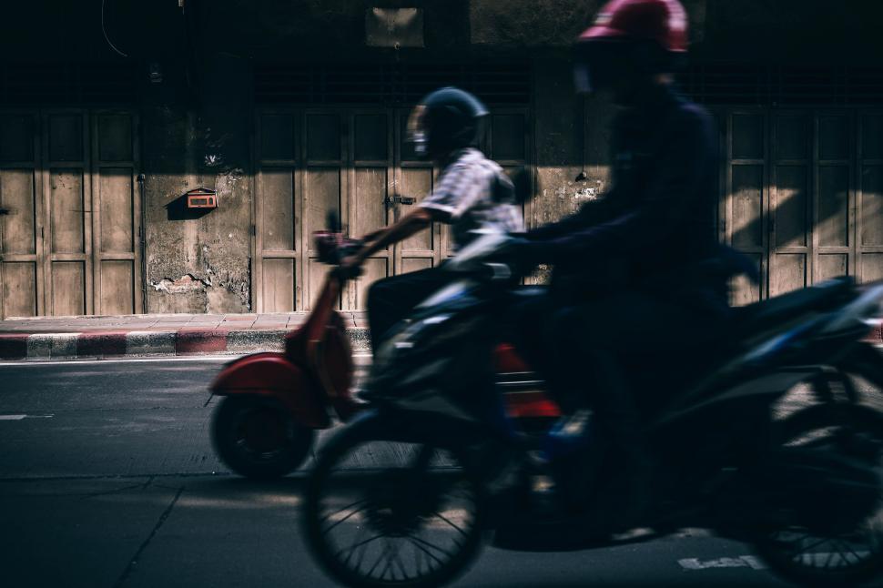 Free Image of Two People Riding Motorcycles on a City Street 