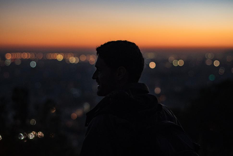 Free Image of Man Standing in Front of City at Sunset 