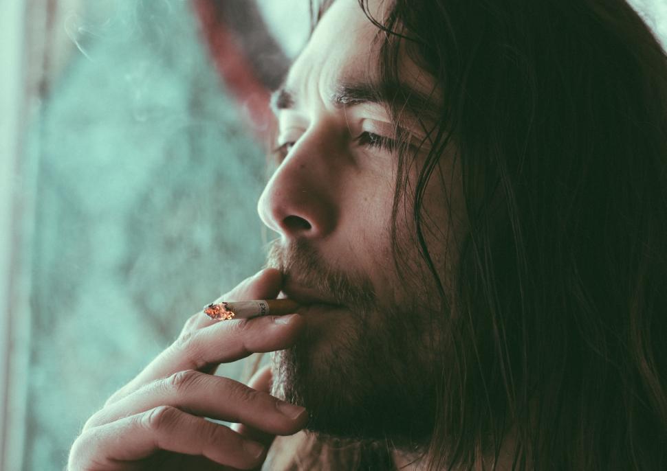 Free Image of Man With Long Hair Smoking a Cigarette 