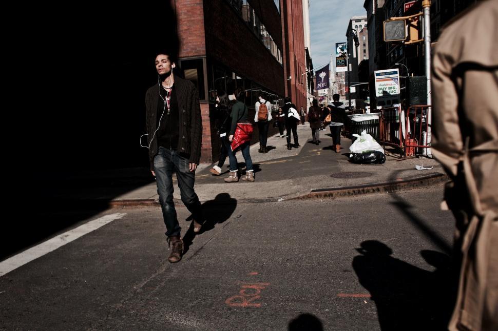 Free Image of Man Riding Skateboard Down Street Next to Tall Buildings 