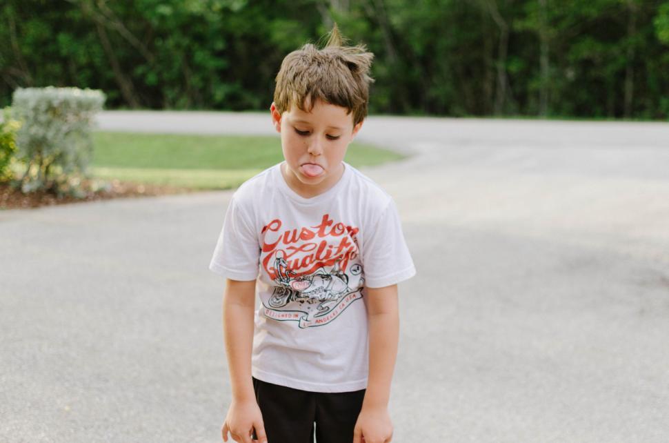 Free Image of Young Boy Holding Skateboard in Driveway 