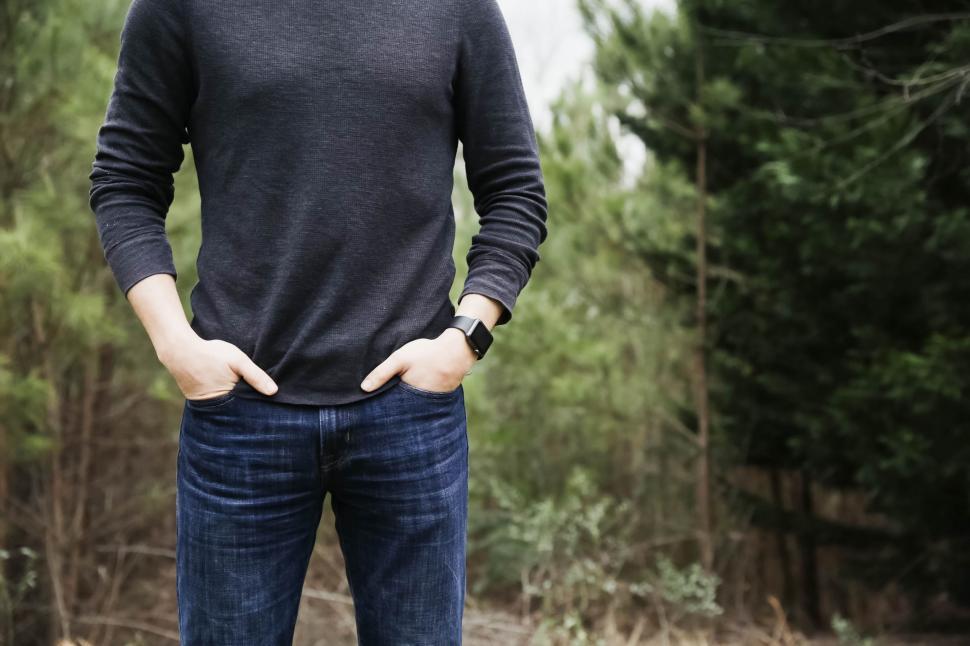 Free Image of Man Standing in Forest With Hands in Pockets 