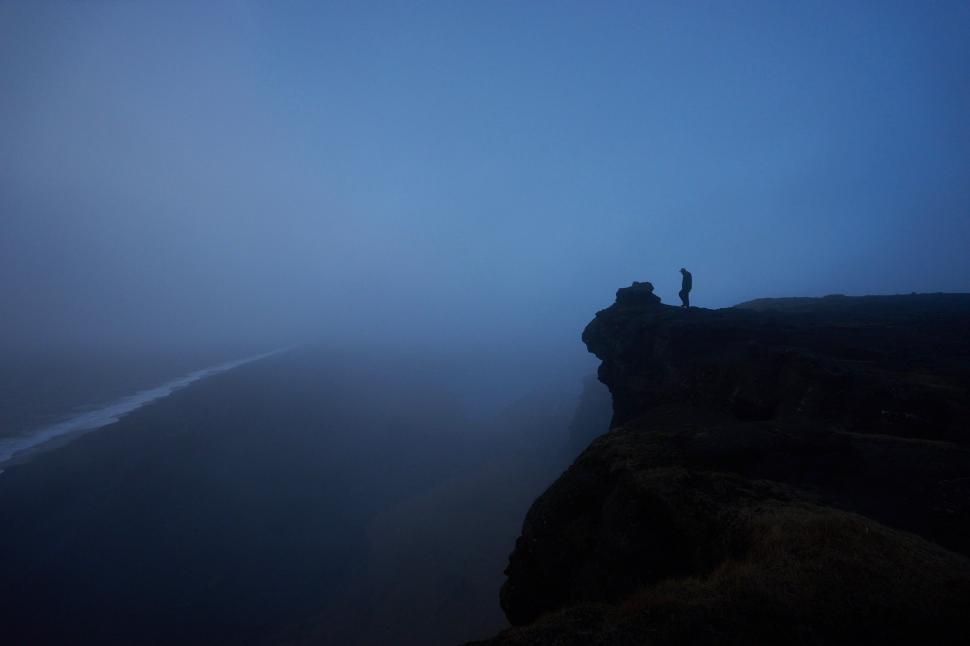 Free Image of Person Standing on Cliff in Fog 