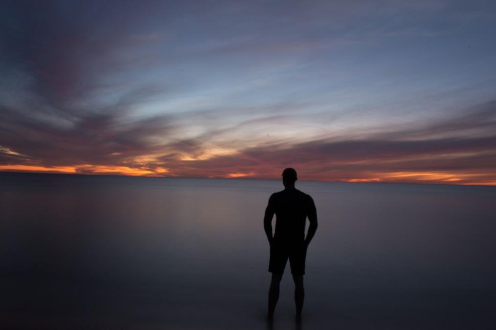 Free Image of Man Standing in the Middle of a Body of Water 