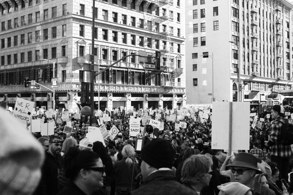 Free Image of Large Crowd of People Standing in Front of Tall Buildings 