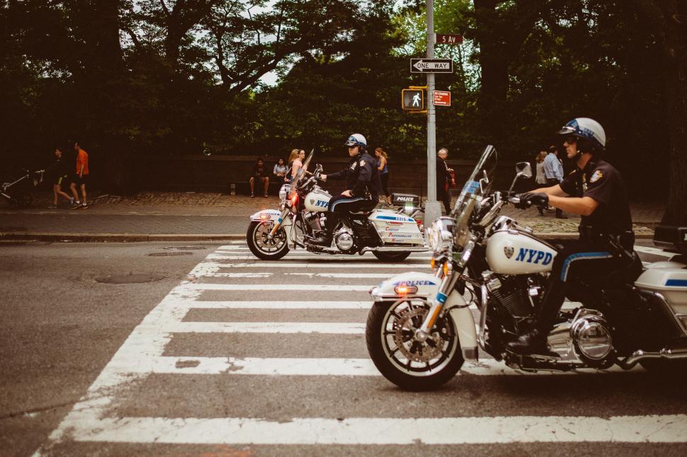 Free Image of Police Officer Riding Motorcycle Across Street 