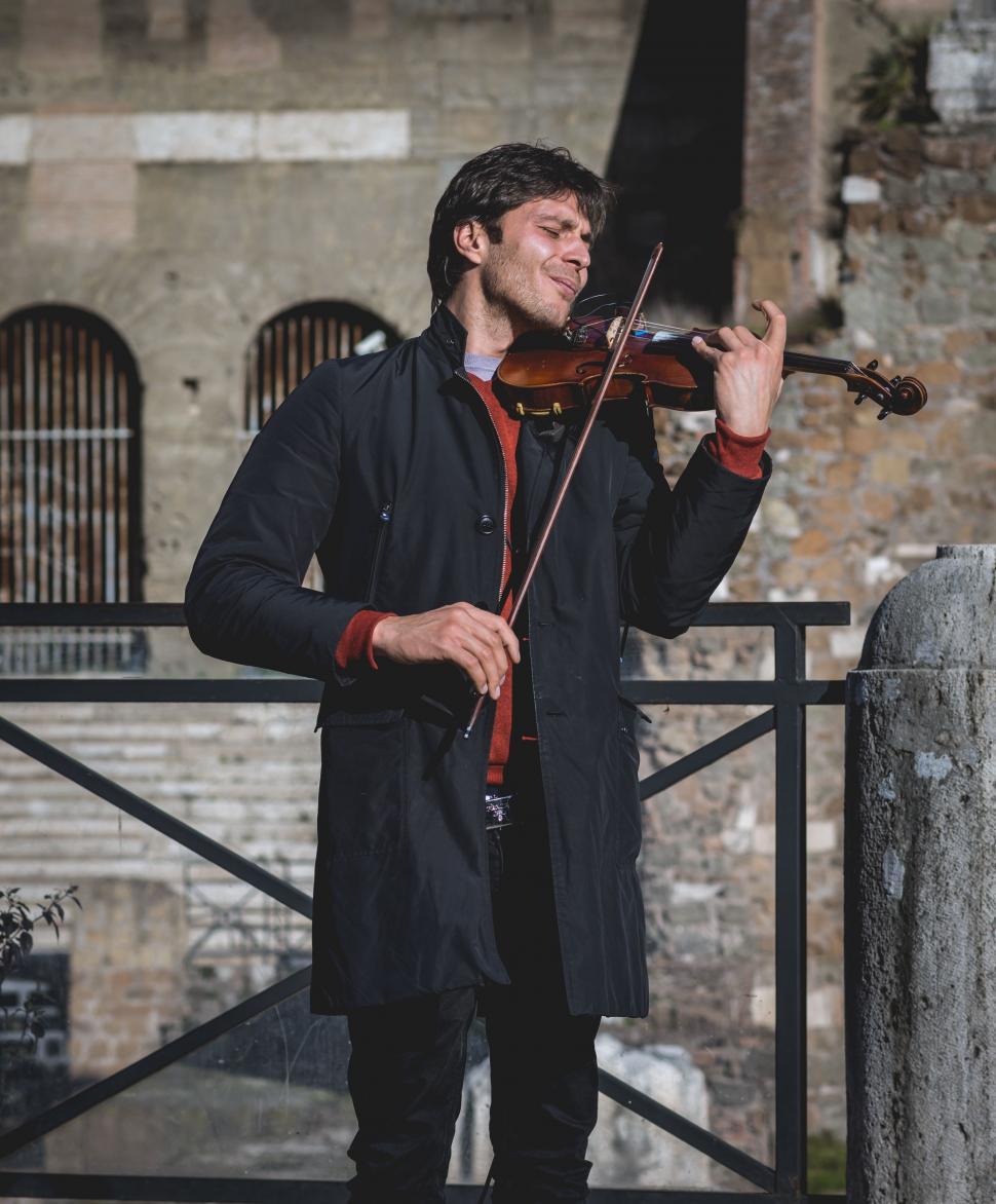 Free Image of Man Playing Violin in Front of Building 