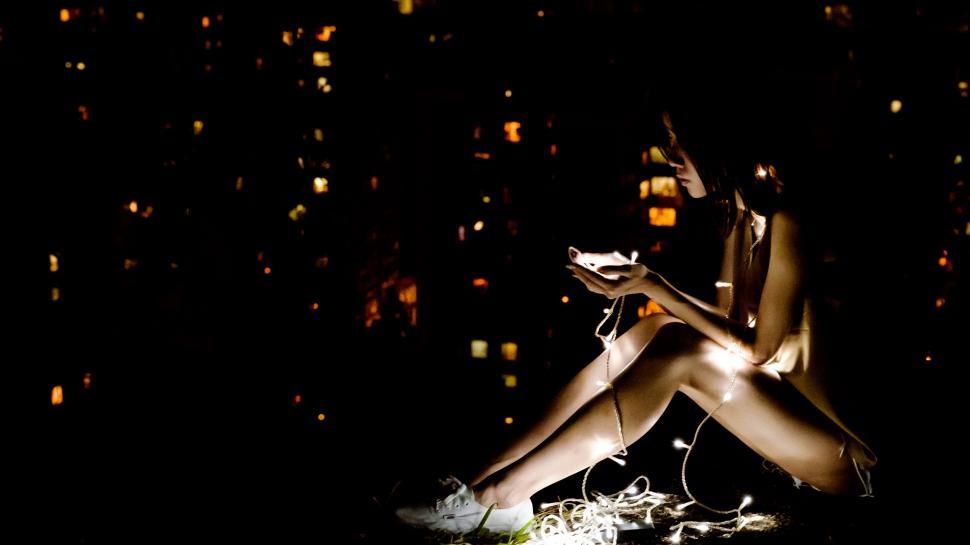 Free Image of Woman Sitting in Dark With Cell Phone 