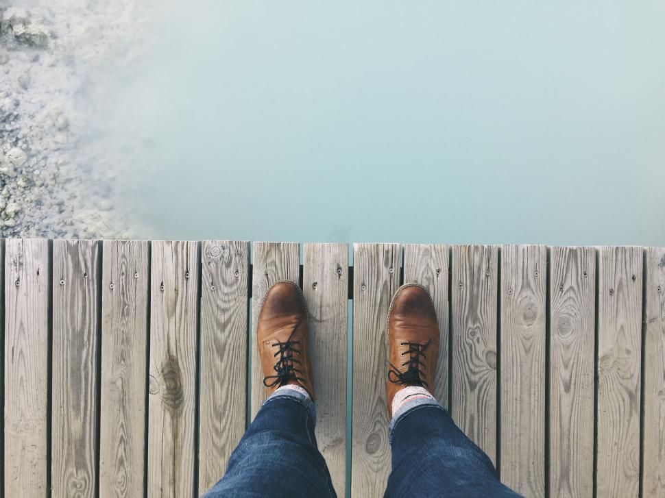 Free Image of Person Standing on Dock With Feet Up 