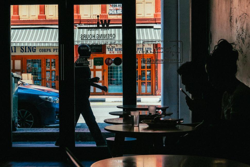 Free Image of Person Walking Out of Restaurant Window 