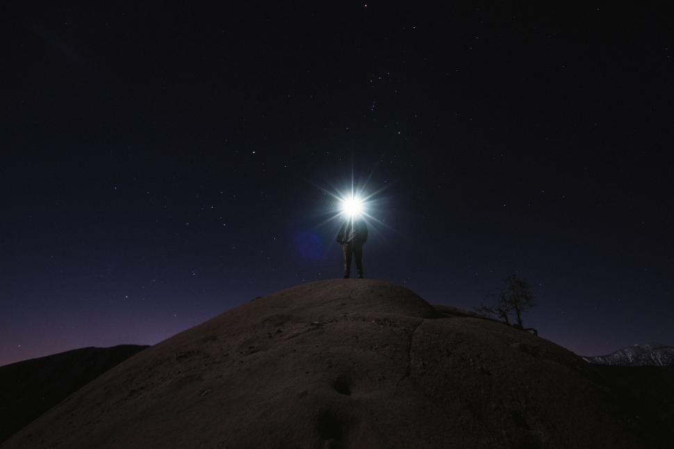 Free Image of Person Standing on Top of Hill at Night 