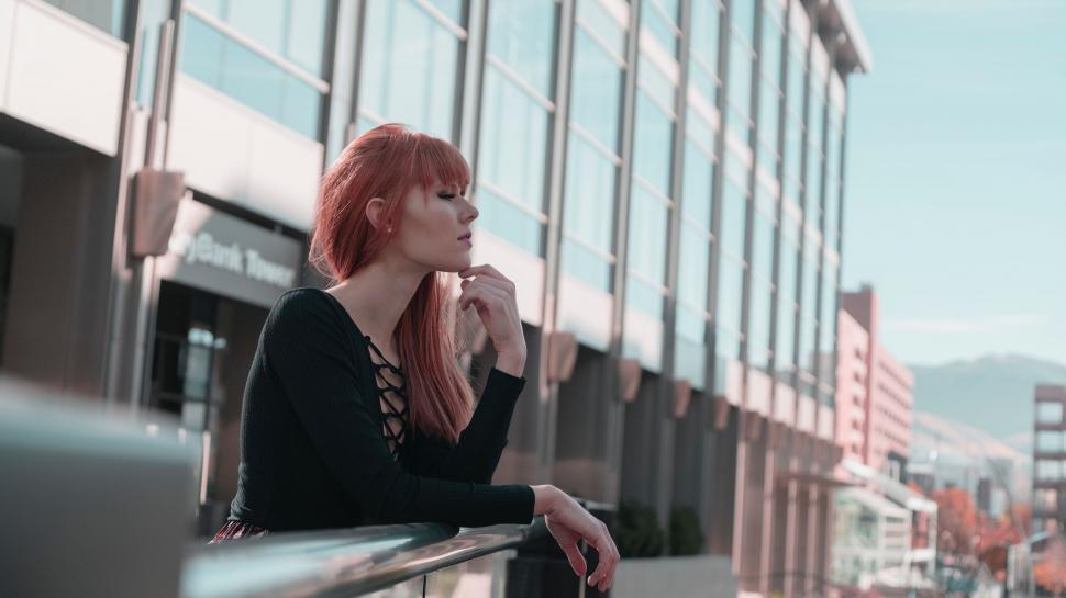Free Image of Woman With Red Hair Standing on Balcony 