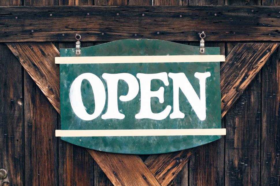 Free Image of Green Open Sign Hanging on Wooden Wall 