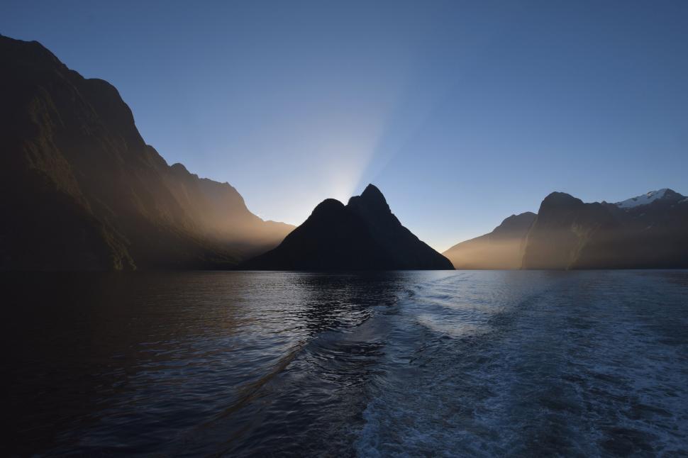 Free Image of Sun Setting Over Mountains on Water 