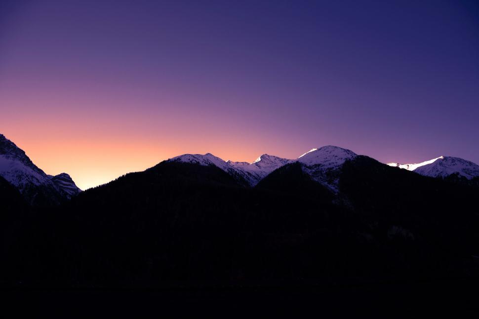 Free Image of Majestic Mountain Range Silhouetted Against Sunset 