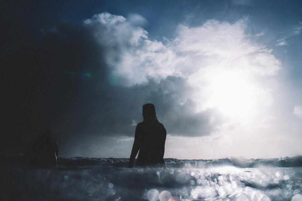 Free Image of Man Standing in Ocean Under Cloudy Sky 
