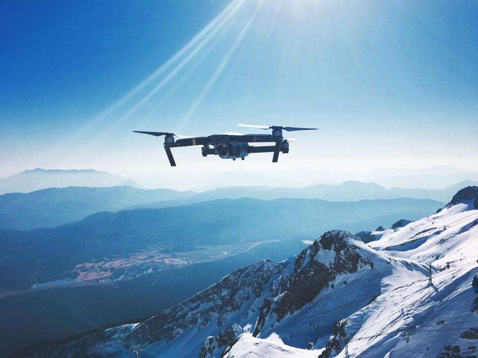 Free Image of Large Propeller Plane Flying Over Snow-Covered Mountain 