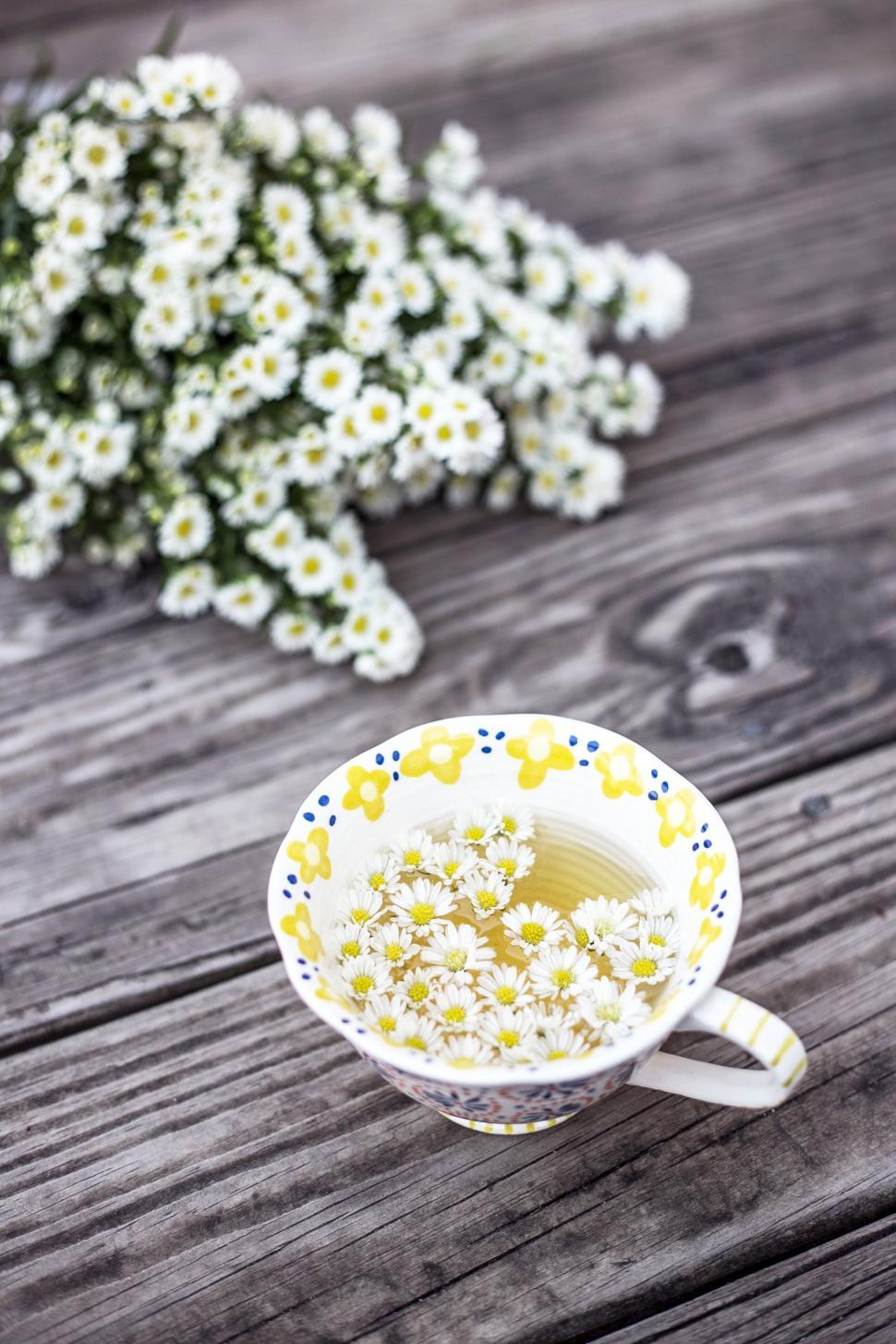 Free Image of Small Yellow and White Bowl Filled With Flowers 
