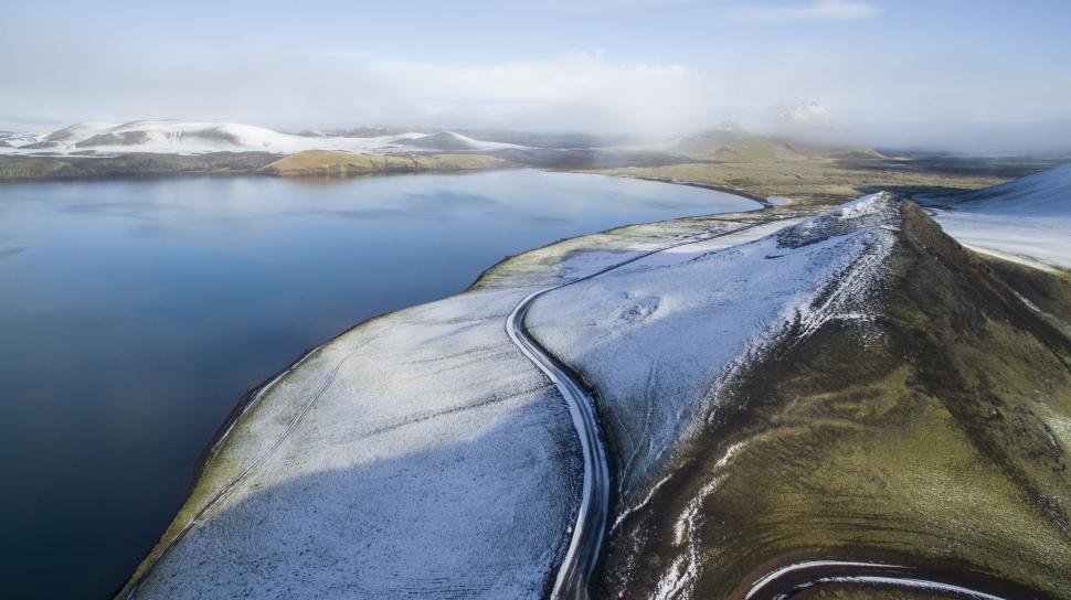 Free Image of Snow-Covered Hills Surrounding Large Body of Water 