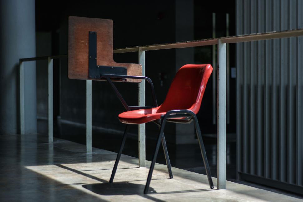 Free Image of Red Chair on Metal Rail 