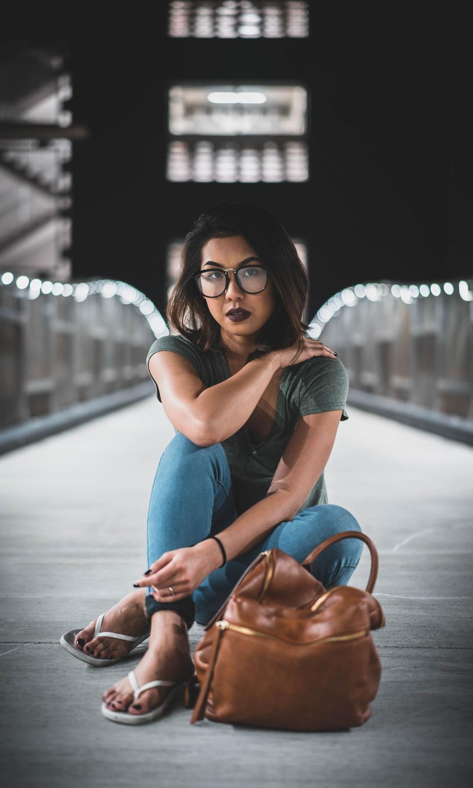 Free Image of Woman Sitting on Ground With Purse 