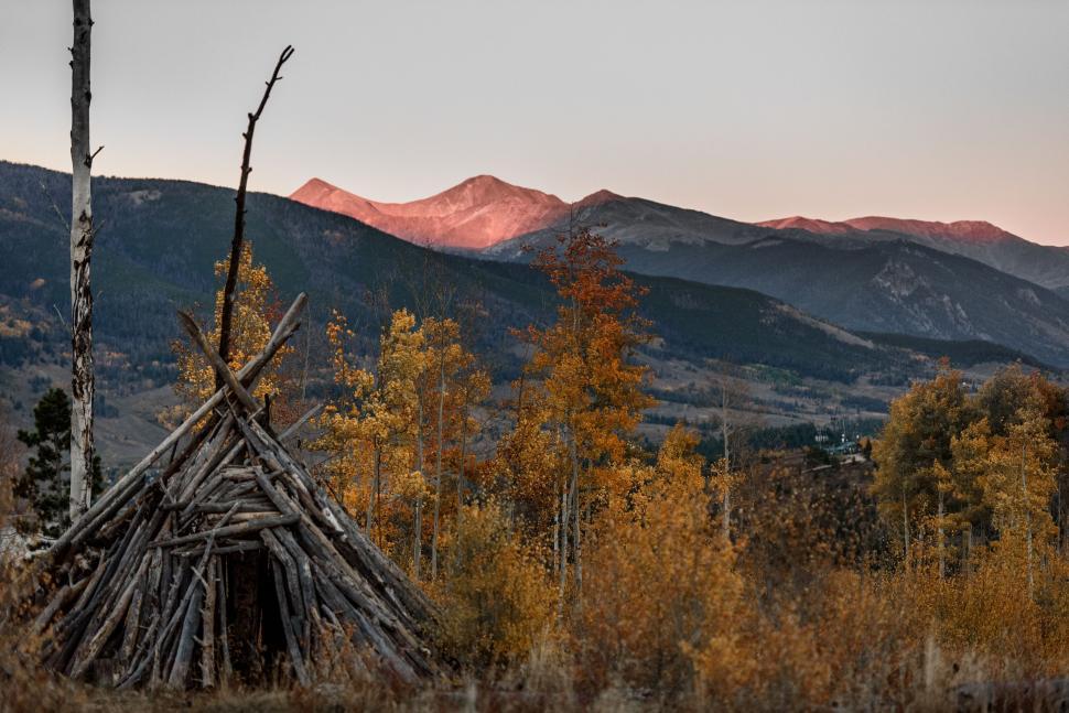 Free Image of Teepee Standing in Field With Mountains in Background 