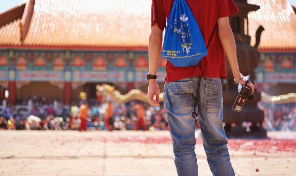 Free Image of Man in Red Shirt With Blue Bag 