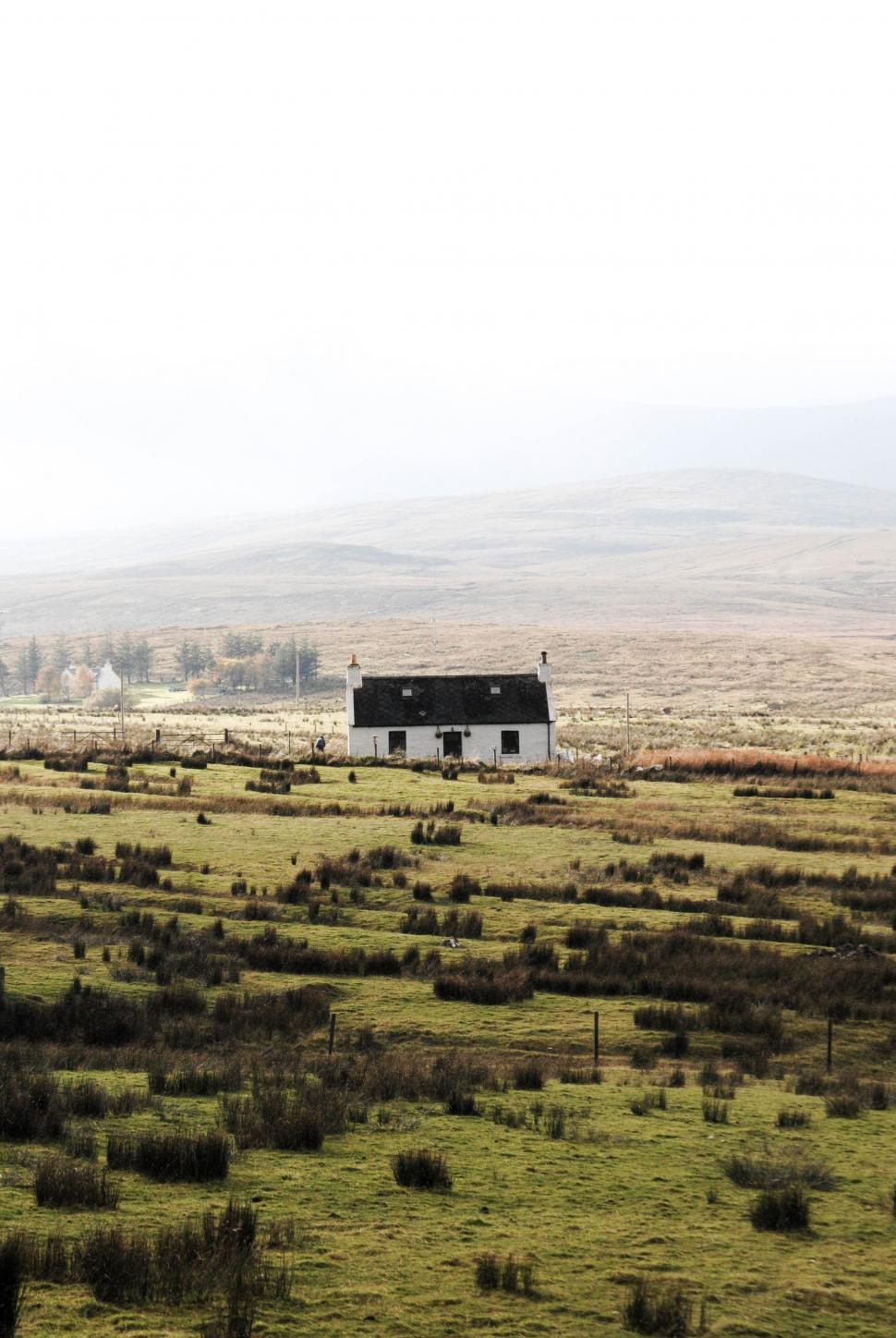 Free Image of Lone House Amidst Field With Distant Mountains 