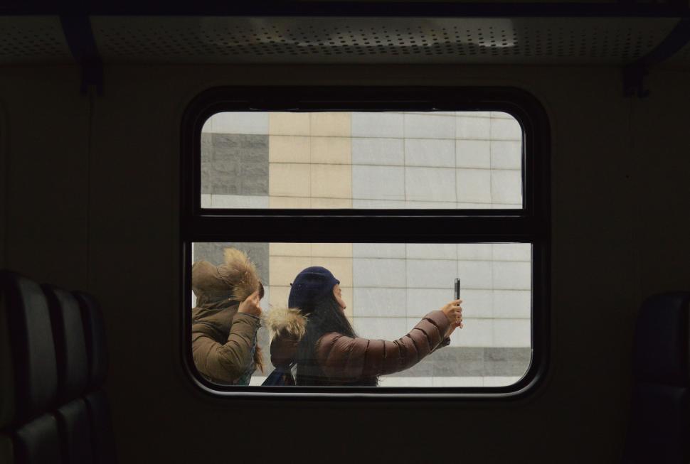 Free Image of Two People Sitting on a Bus Looking Out the Window 