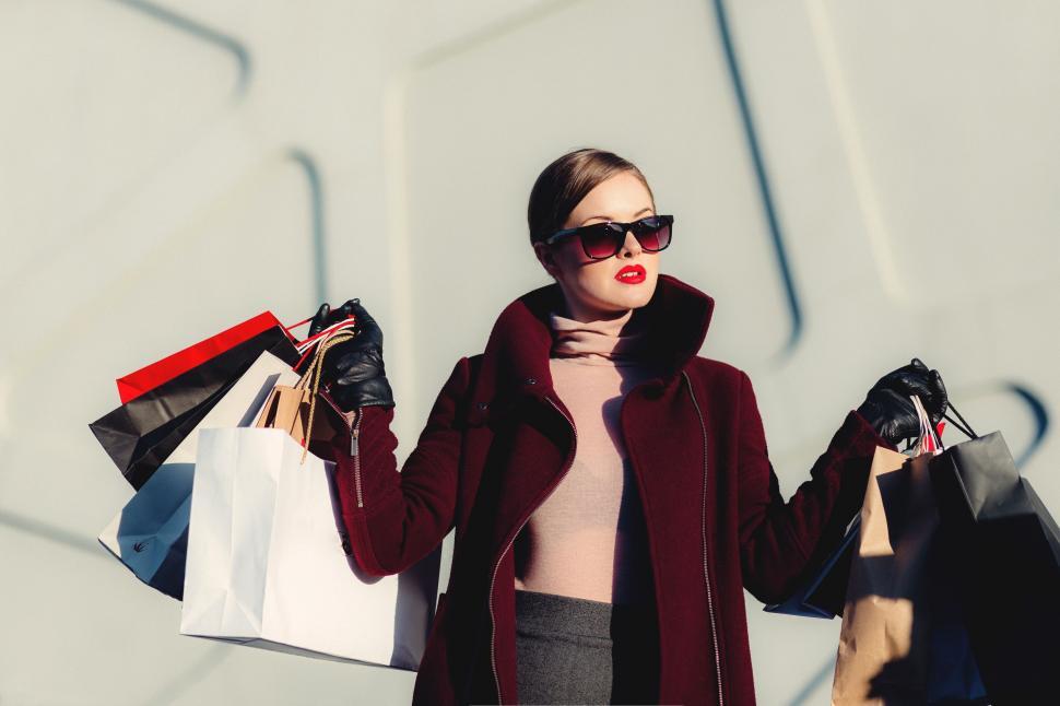 Free Image of Woman Holding Shopping Bags and Talking on Cell Phone 