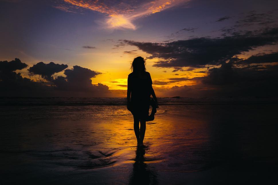 Free Image of Woman Walking on Beach at Sunset 