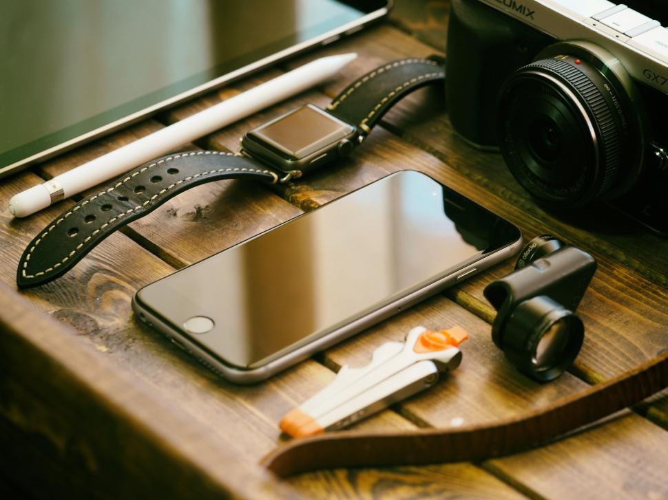 Free Image of Wooden Table With Camera and Cell Phone 
