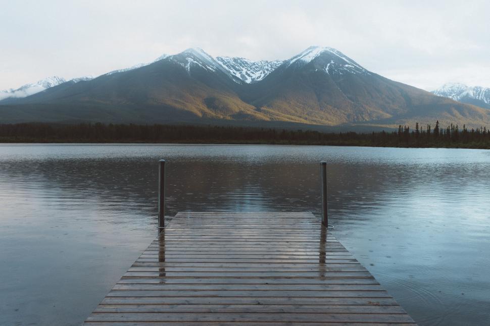 Free Image of Dock on a Lake With Mountains in Background 