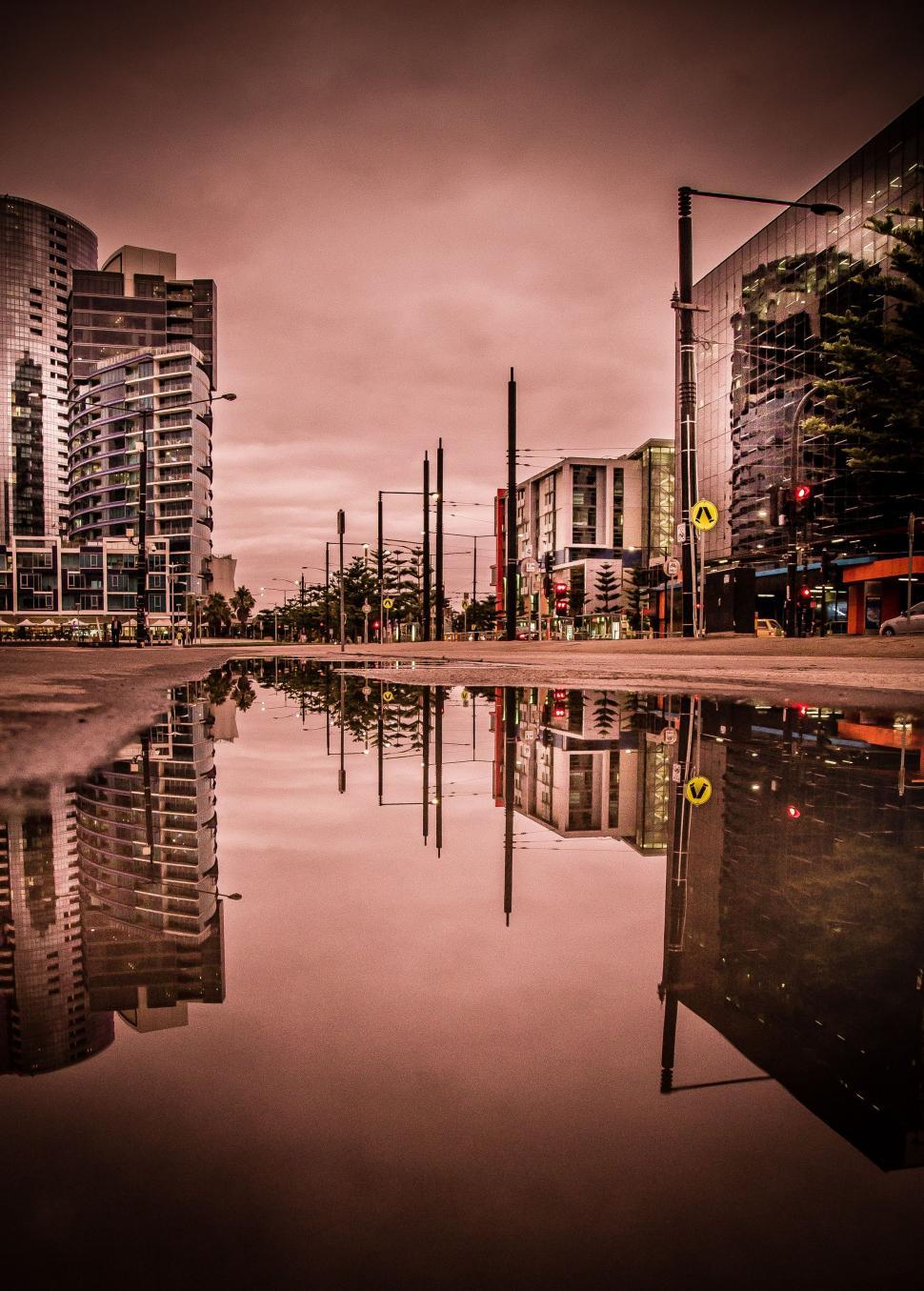 Free Image of Urban Buildings Reflection in Water Puddle 