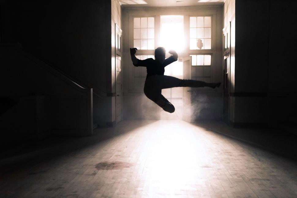 Free Image of Person Jumping in Front of Door 