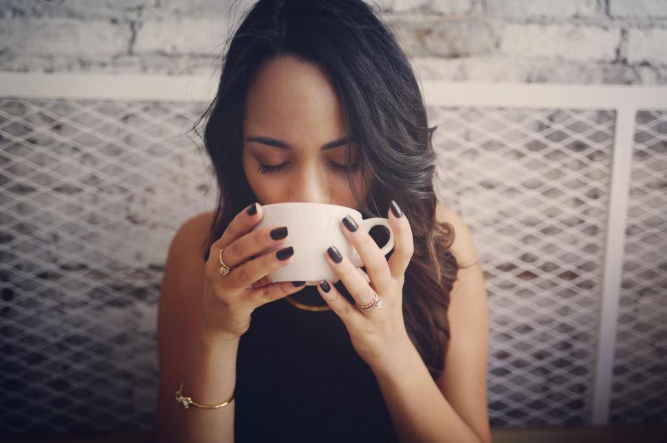 Free Image of Woman Holding Cup of Coffee in Front of Face 