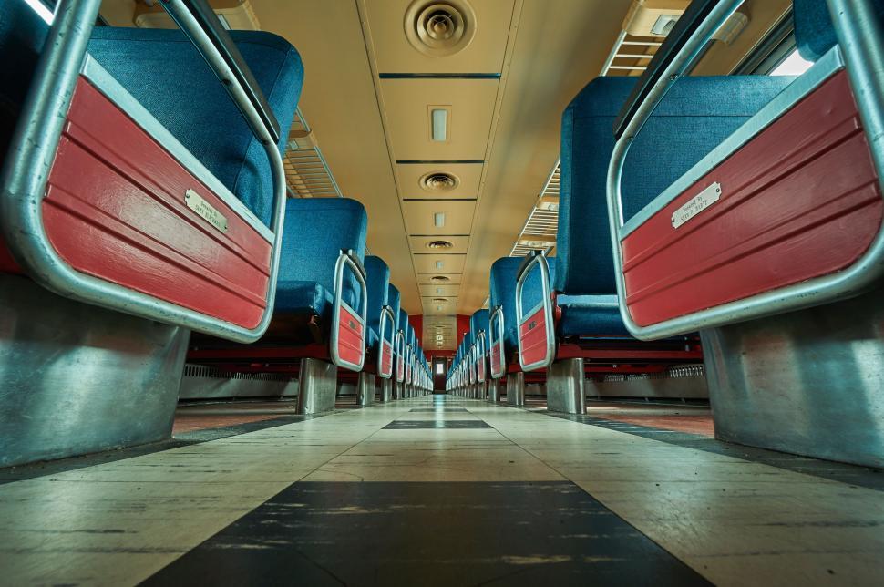 Free Image of Long Hallway With Blue and Red Seats 