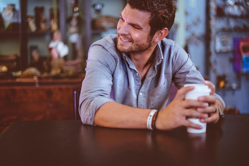 Free Image of Man Sitting at Table With Cup of Coffee 