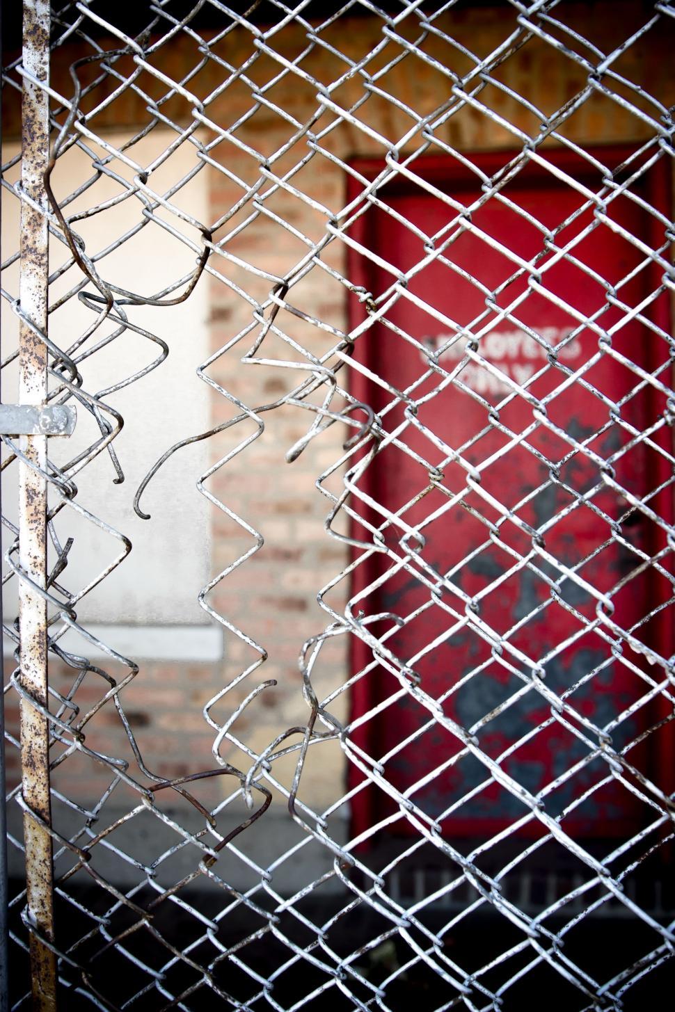 Free Image of Red Door Behind Chain Link Fence 