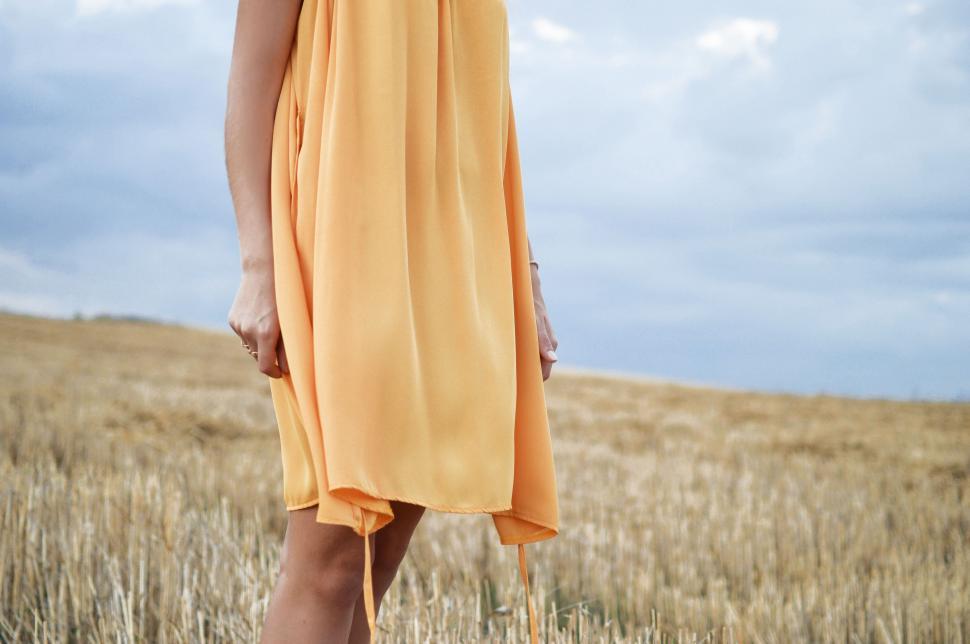 Free Image of Woman in Yellow Dress Standing in Field 