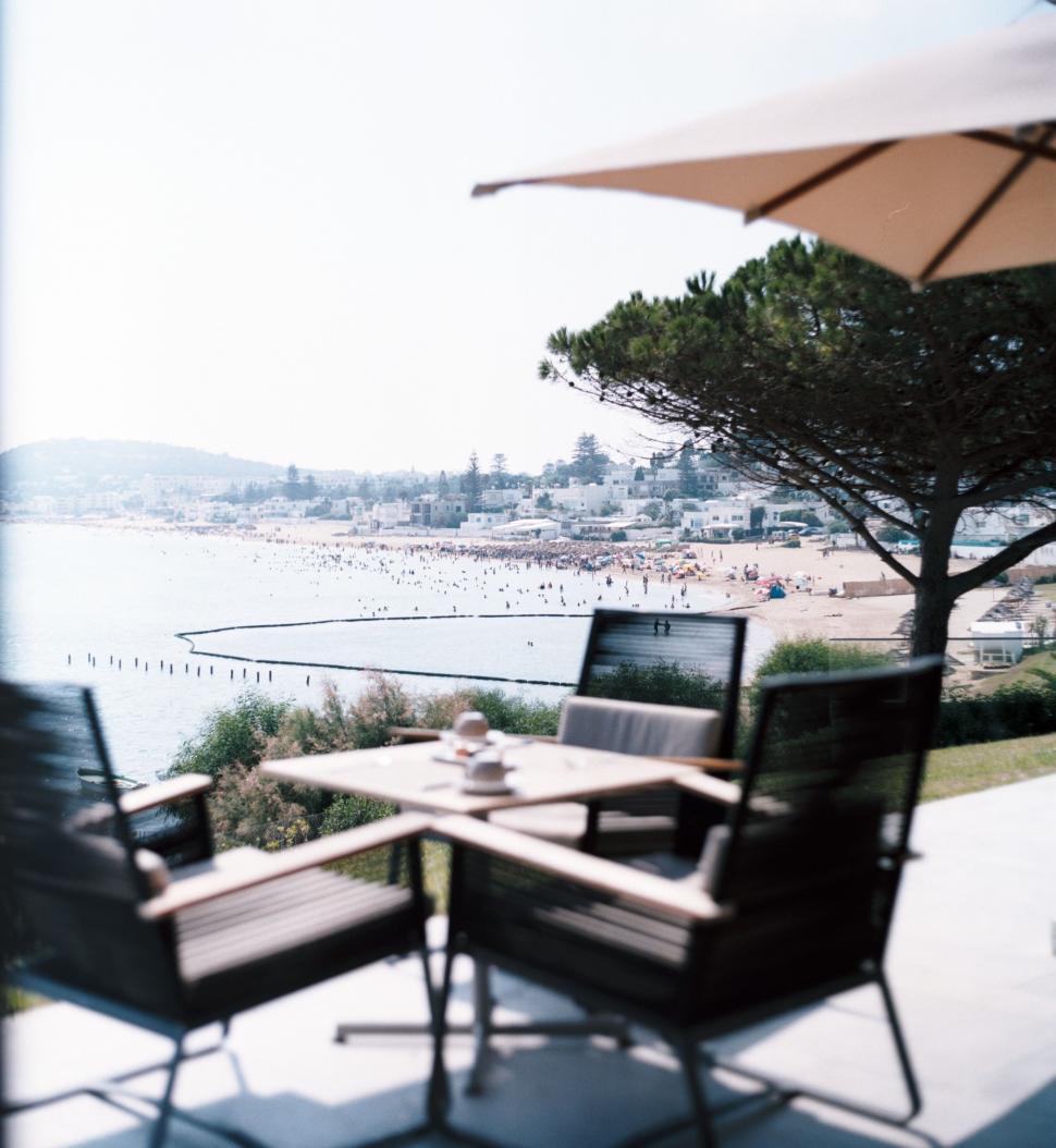 Free Image of Two Chairs and a Table on a Beachfront Patio 
