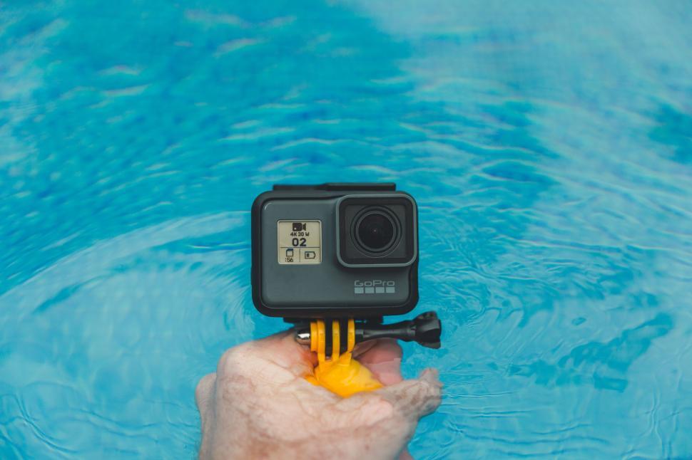Free Image of Person Holding a Camera in a Pool 