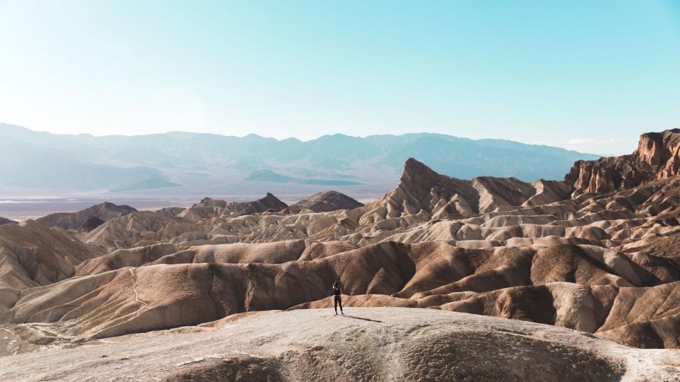 Free Image of Man Standing on Top of a Large Rock Formation 
