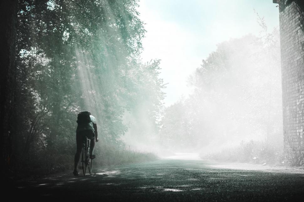 Free Image of Person Riding Bike Down Dirt Road 