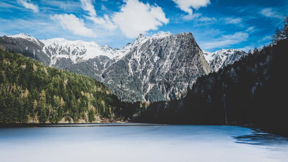 Free Image of Snow Covered Mountains Surrounding Lake Under Blue Sky 
