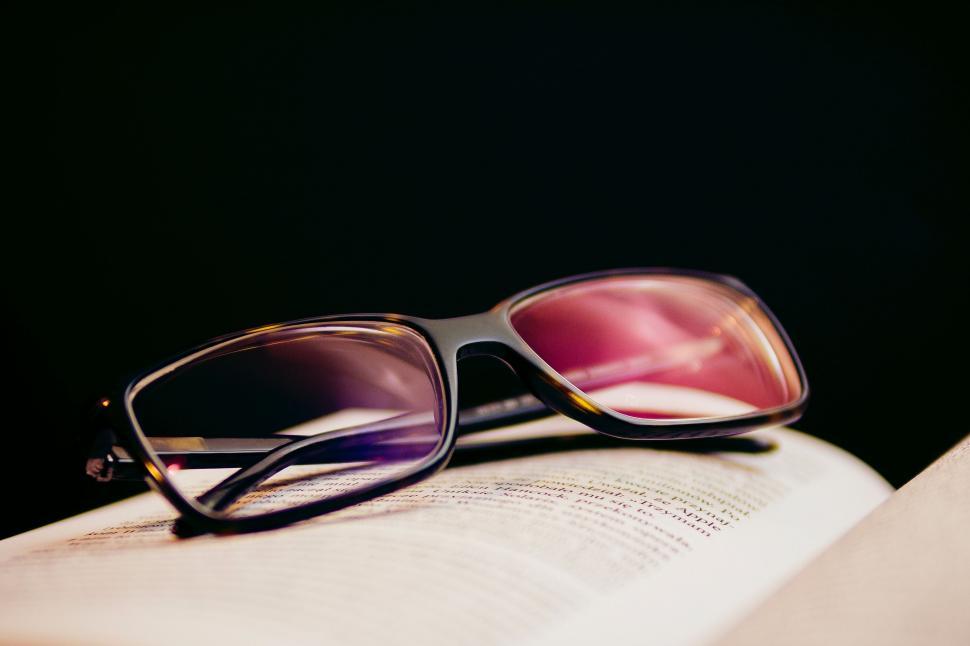 Free Image of Glasses Resting on Open Book 
